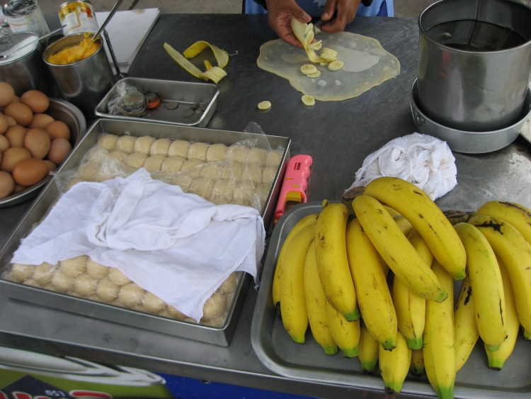 Spis en bananpandekage i Bangkok